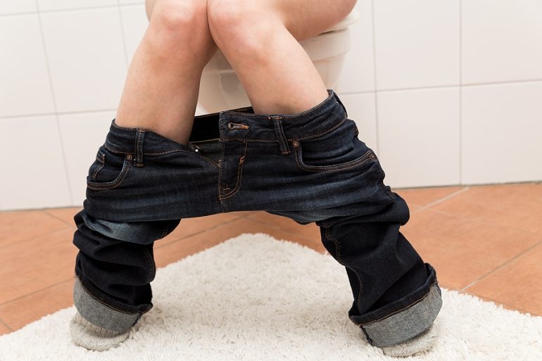 Woman on Toilet with Upset Stomach