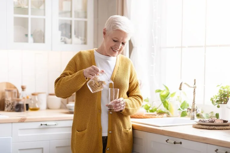 lady drinking well water in kitchen