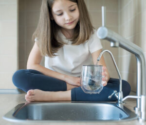 girl drinking from reverse osmosis system