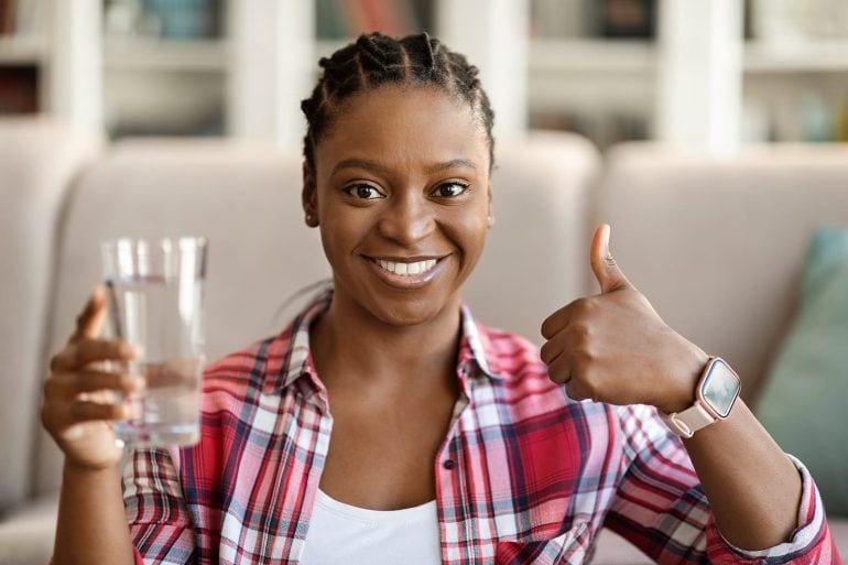 woman drinking water at home