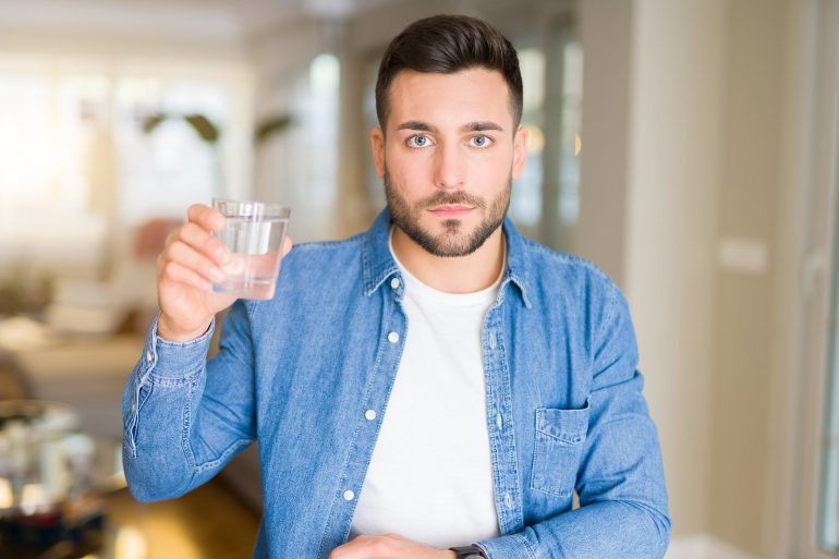 man holding glass of water