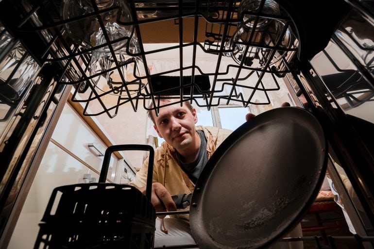 man looking at dishwasher